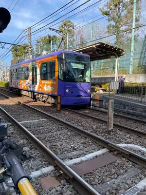 a blue and orange train pulling into a train station at Aurora 5 in Tokyo