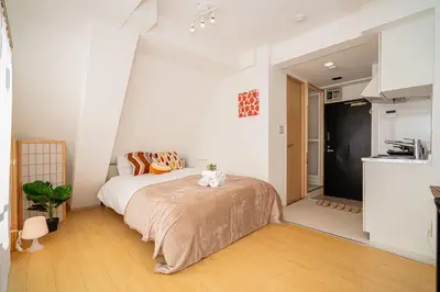 a bedroom with a bed and a kitchen at Aurora 5 in Tokyo