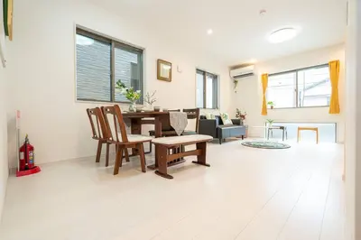 a living room with a wooden table and chairs at \u58a8\u7530\u533a\u72ec\u680b\u4e09\u5c42\u522b\u5885.\u6674\u7a7a\u5854.\u6d45\u8349\u5bfa\u5546\u5708.\u76f4\u8fbe\u673a\u573a\u3001\u6da9\u8c37\u3002\u6709\u5ba4\u5185\u5c0f\u578b\u505c\u8f66\u4f4d\u3001\u65e0\u7ebf\u7f51 in Tokyo