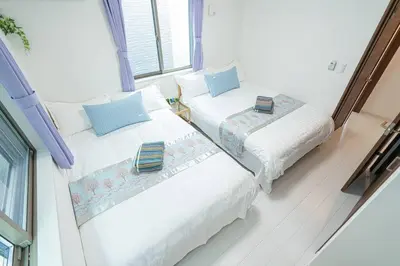 two beds sitting next to a window in a room at \u58a8\u7530\u533a\u72ec\u680b\u4e09\u5c42\u522b\u5885.\u6674\u7a7a\u5854.\u6d45\u8349\u5bfa\u5546\u5708.\u76f4\u8fbe\u673a\u573a\u3001\u6da9\u8c37\u3002\u6709\u5ba4\u5185\u5c0f\u578b\u505c\u8f66\u4f4d\u3001\u65e0\u7ebf\u7f51 in Tokyo