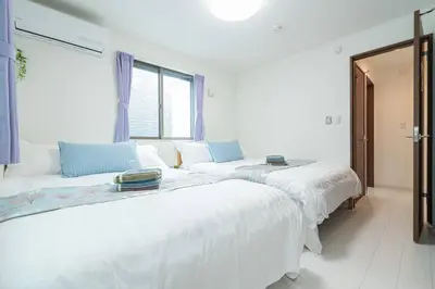 two white beds in a room with a window at \u58a8\u7530\u533a\u72ec\u680b\u4e09\u5c42\u522b\u5885.\u6674\u7a7a\u5854.\u6d45\u8349\u5bfa\u5546\u5708.\u76f4\u8fbe\u673a\u573a\u3001\u6da9\u8c37\u3002\u6709\u5ba4\u5185\u5c0f\u578b\u505c\u8f66\u4f4d\u3001\u65e0\u7ebf\u7f51 in Tokyo