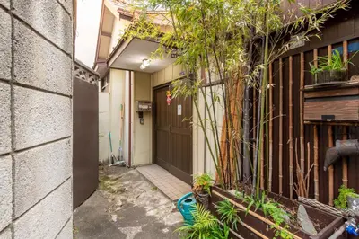a hallway of a house with a door and plants at \u795e\u8c37\u6238\u5efa in Tokyo