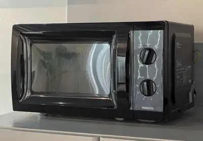 a microwave oven sitting on top of a counter at \u8239\u5800\u6238\u5efa in Tokyo