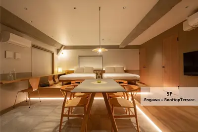 a room with two beds and a table and chairs at M/W HOTEL in Tokyo