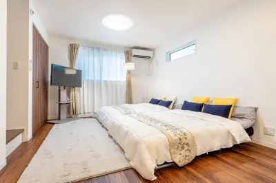 a bedroom with a large bed and a television at \u5343\u99c4\u6728\u6238\u5efa in Tokyo