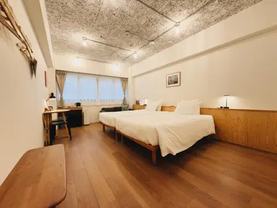 a bedroom with a large bed and a desk at HERE.Tokyo in Tokyo