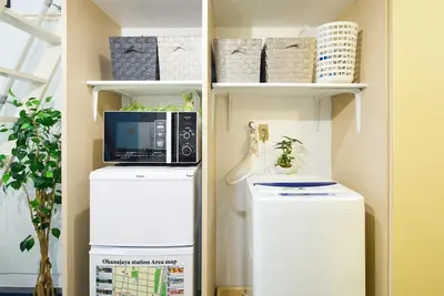 a laundry room with a microwave and a washer and dryer at SC 102 Cozy Private Stay with Loft Near Station Free WiFi in Tokyo