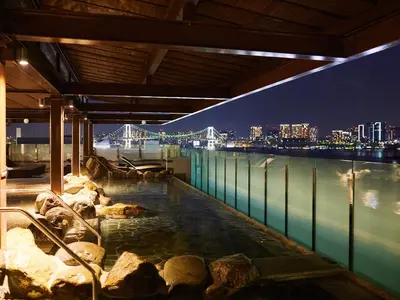 a hot tub on top of a building with a view of a bridge at Tokyo Toyosu Manyo Club in Tokyo
