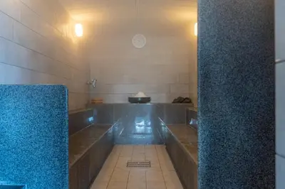 a bathroom with two sinks and a blue wall at Tokyo Toyosu Manyo Club in Tokyo