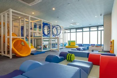 a childrens play room with blue chairs and a slide at Tokyo Toyosu Manyo Club in Tokyo