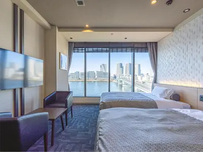 a hotel room with two beds and a large window at Tokyo Toyosu Manyo Club in Tokyo