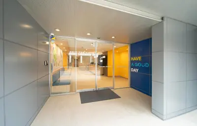 a lobby with a glass door with a sign have a good day at Hop Inn Tokyo Ueno in Tokyo
