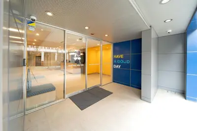 an office hallway with glass doors and a sign have a good day at Hop Inn Tokyo Ueno in Tokyo