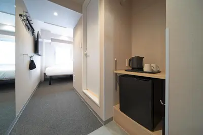 a room with a tv and a room with a bed at Hop Inn Tokyo Ueno in Tokyo