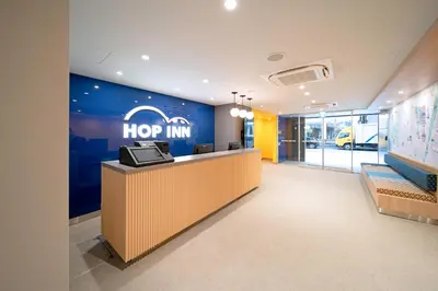 an office lobby with a hop inn sign on the wall at Hop Inn Tokyo Ueno in Tokyo