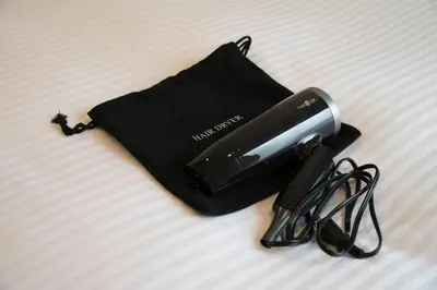 a hair dryer and a pair of glasses on a bed at Hop Inn Tokyo Ueno in Tokyo