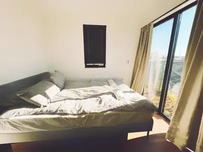 a bed in a room with a large window at \u6795\u6728 New house with Huge View for Family-Group in Tokyo