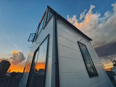 a building with glass windows with a sunset in the background at \u6795\u6728 New house with Huge View for Family-Group in Tokyo