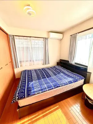 a bed in a room with two windows at \u5409\u5409\u306e\u5bb6 in Tokyo