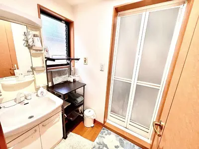 a bathroom with a sink and a glass shower door at \u5409\u5409\u306e\u5bb6 in Tokyo