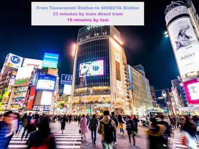 a crowd of people crossing a busy city street at night at Skyterrace Love Asakusa Downtown in Tokyo