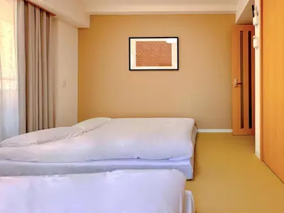 two beds in a room with a picture on the wall at Skyterrace Love Asakusa Downtown in Tokyo
