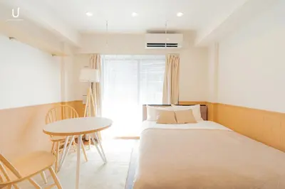 a small bedroom with a bed and a table at unito residence HIKAWADAI in Tokyo