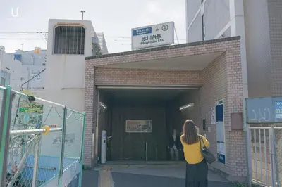 a woman is standing outside of a building at unito residence HIKAWADAI in Tokyo