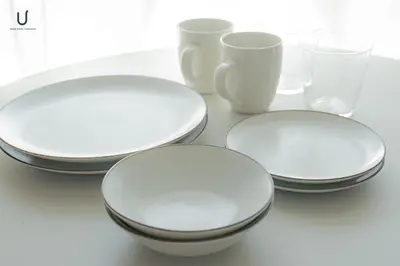 four white plates and glasses on a table at unito residence HIKAWADAI in Tokyo