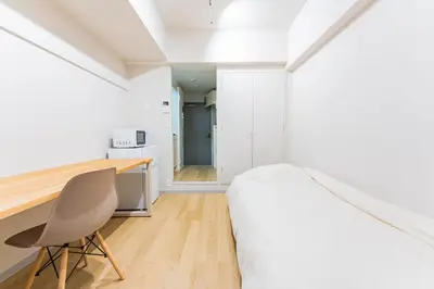 a bedroom with a bed and a desk and a chair at unito residence IKEBUKURO in Tokyo