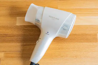 a white hair dryer sitting on a wooden table at unito residence IKEBUKURO in Tokyo