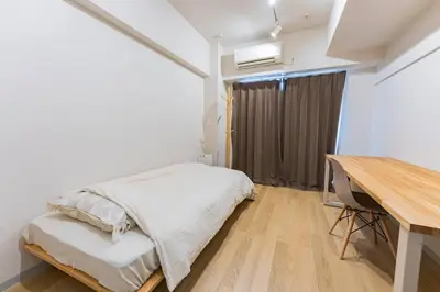 a bedroom with a bed and a desk and a table at unito residence IKEBUKURO in Tokyo