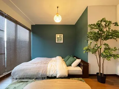 a bedroom with a bed and a green wall at All room Skytree view hotel-Near Ryukoku,Asakusa,kinshicho in Tokyo