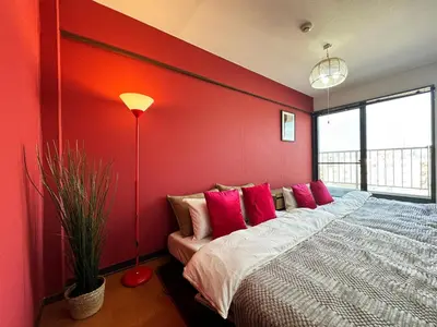 a bedroom with a large bed with red walls at All room Skytree view hotel-Near Ryukoku,Asakusa,kinshicho in Tokyo