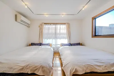 two beds in a room with a window at 2 shower rooms #Shinjuku 5 min walk from station ,projector in Tokyo