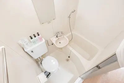 a white bathroom with a toilet and a sink at Mi-WIND SHINJUKU in Tokyo