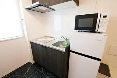 a small kitchen with a refrigerator and a microwave at \u30ea\u30ea\u30cf\u30a6\u30b9\u7b39\u585a in Tokyo