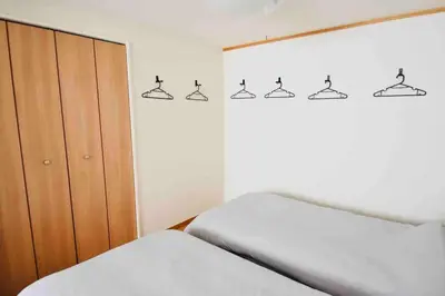 a bedroom with two beds and a window with hangers at \u30b9\u30ab\u30a4\u30c4\u30ea\u30fc\u30fb\u6d45\u8349\u8fd1\u304f\uff01\u6210\u7530\u30fb\u7fbd\u7530\u304b\u3089\u30a2\u30af\u30bb\u30b9\u826f\u597d\uff01\u5927\u4eba\u6570\u6ede\u5728\u5411\u3051\u3002 in Tokyo