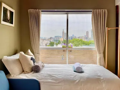 a bed with two hats on it in front of a window at \u65b0\u5bbf\u533a\u65e9\u7a3b\u7530\u5730\u94c16\u5206\u949f\u4e24\u5ba4\u666f\u89c2\u516c\u5bd3 in Tokyo