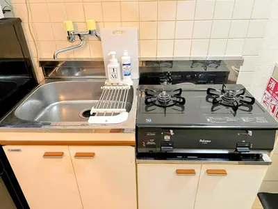 a kitchen with a stove and a sink at \u30e1\u30be\u30f3\u30af\u30ec\u30b9\u30bf in Tokyo