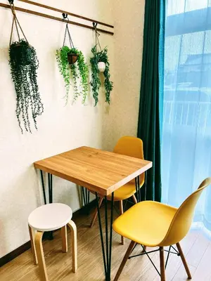 a table and chairs in a room with plants on the wall at \u30e1\u30be\u30f3\u30af\u30ec\u30b9\u30bf in Tokyo