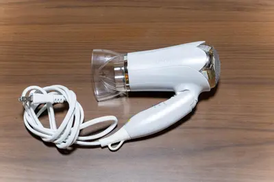 a white hair dryer sitting on a wooden table at SENJU Nakacho HOUSE , \u5343\u4f4f\u4ef2\u753aHOUSE in Tokyo
