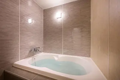 a large bath tub in a bathroom with tiles at Hotel Plantan - Adult Only in Tokyo