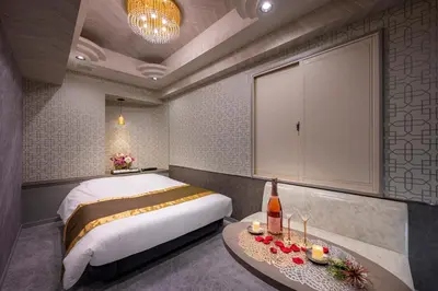 a bedroom with a bed and a table with a bottle of wine at Hotel Plantan - Adult Only in Tokyo