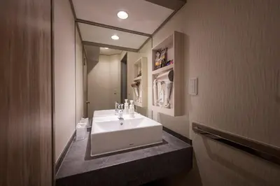 a bathroom with a white sink and a mirror at Hotel Plantan - Adult Only in Tokyo