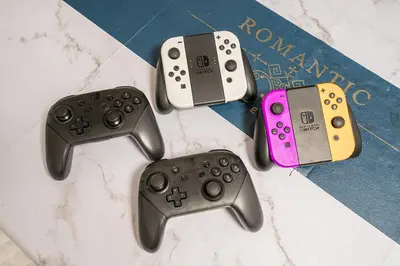 four video game controllers sitting on top of a book at \u79cb 5GWIFI*\u6771\u4eac\u5343\u4ee3\u7530\u533a\u7687\u5c451km~King BLdg. in Tokyo