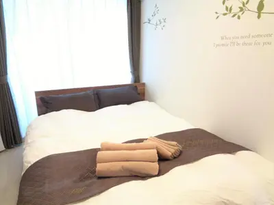 a bed with two towels on it with a window at EMILIO Nishi-Shinjuku 101,201,202 - Vacation STAY 64263v in Tokyo