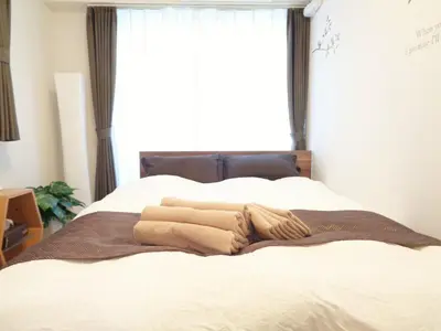 a bed with two blankets on it with a window at EMILIO Nishi-Shinjuku 101,201,202 - Vacation STAY 64263v in Tokyo