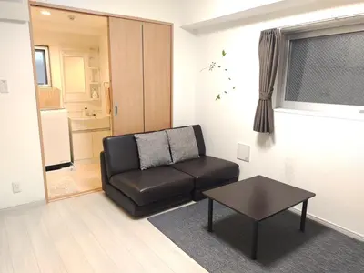a living room with a black chair and a table at EMILIO Nishi-Shinjuku 101,201,202 - Vacation STAY 64263v in Tokyo