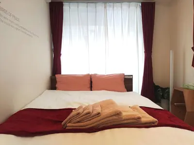 a bed with a blanket on it with a window at EMILIO Nishi-Shinjuku 101,201,202 - Vacation STAY 64292v in Tokyo